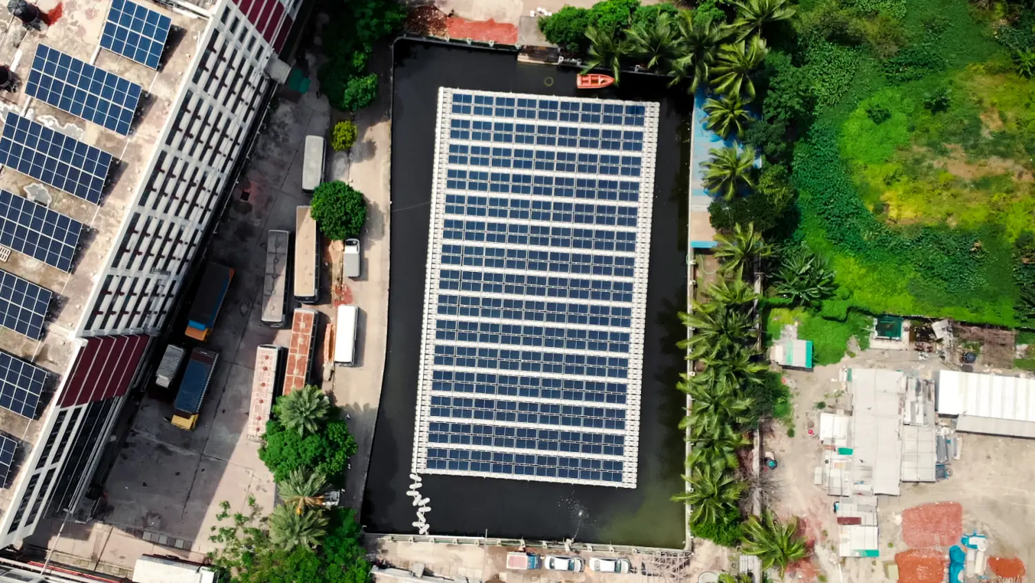 Elevated view of AKH Fashions floating solar array with city backdrop in Bangladesh